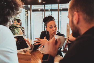 A group of friends hanging out in a cafe, and among them is a tablet.