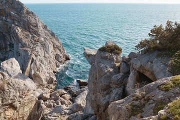 Seascape, sea and mountains, rocks and tropical trees, wild stone grotto, water breaking on rocks