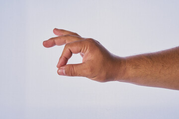 Mano de hombre adulto latino haciendo un gesto en un fondo blanco