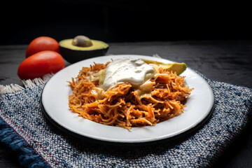 Dry fideo with cheese and sour cream on dark background