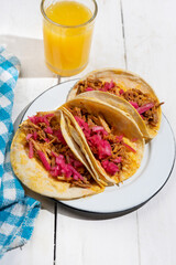 Pork tacos called cochinita pibil with purple onion on white background. Mexican tacos