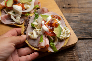 Corn toast with ham and Oaxaca cheese on wooden background. Mexican food