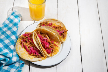 Pork tacos called cochinita pibil with purple onion on white background. Mexican tacos