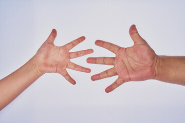 Mano de hombre adulto latino haciendo un gesto con la mano de un niño en un fondo blanco