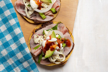 Corn toast with ham and Oaxaca cheese on white background. Mexican food