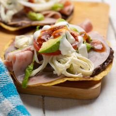 Corn toast with ham and Oaxaca cheese on white background. Mexican food