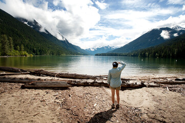 Fototapeta na wymiar A woman looks out over Birkenhead Lake, near Whistler British Columbia, Canada.