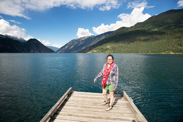 Fototapeta na wymiar A woman on the docks at Anderson Lake, north of Whistler British Columbia, Canada.