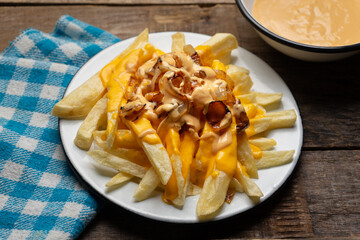 Animal style fries with cheese and caramelized onion on wooden background