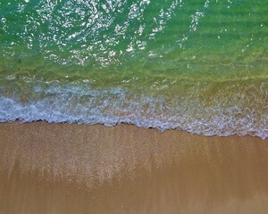 Beach aerial view, amazing green colors with sand and short waves