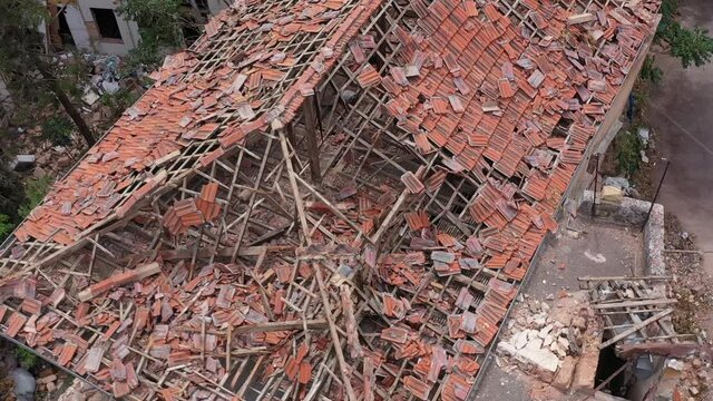 Beirut, Lebanon, 2020: day drone going down shot top view of destroyed tiles on the rooftop of house due to the 4 August explosion