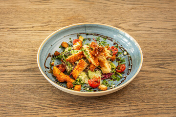 Caesar salad with fresh ingredients, split cherry tomatoes and chives with balsamic vinegar