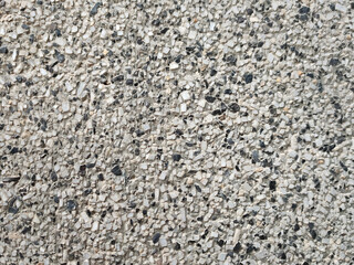 background wall of small gray stone with black splashes
