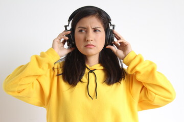 Mujer con audífonos con expresión de disgusto.
