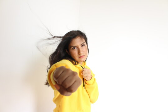 Mujer simula un movimiento de combate con el cabello suelto