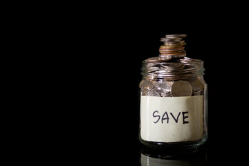 Savings deposit coins in a clear glass bottle.