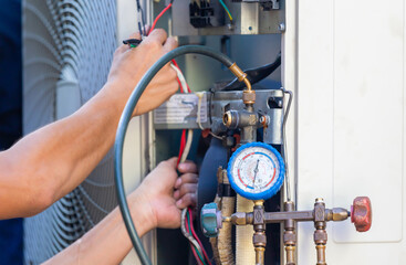 Focus at the pressure gauge, Technician team checking leakage air conditioning system, Air Conditioning Repair man checking and fixing modern air conditioning system