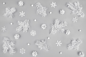 Festive Christmas or winter pattern made of natural fluffy white fir branches and wood snowflakes on solid gray background. Trendy simple minimal monochrome xmas template. Top view, flat lay style.