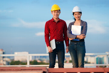 Delighted engineers on rooftop looking at camera