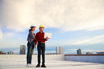 Asian engineers with laptop on roof of building