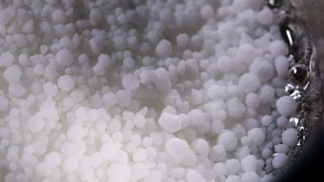 Melting sugar isomalt in a saucepan. Sugar caramelization. Sugar mass to produce candy. Close up.