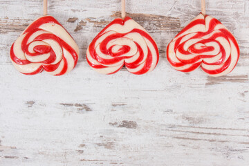 Sweet lollipop in shape of heart on rustic board. Surprise for birthday, valentine or different occasions. Place for text