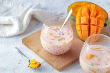 two cups of creamy mango sago dessert from Hongkong. made from mango juice, jelly, sago pearl, evaporated milk and sweetened condensed milk. Served cold.