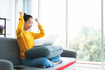 Excited female feeling euphoric celebrating online win success achievement result, young asian...