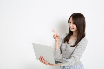 パソコンを持って指差ししている日本人女性