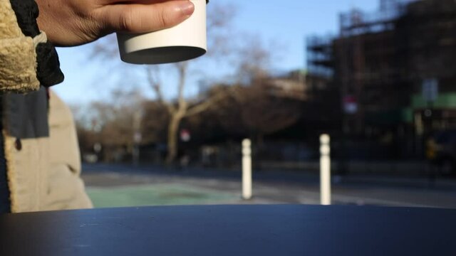 Person drinking a hot cup of tea outside in cold weather