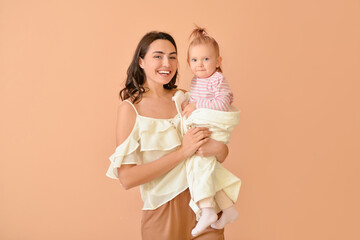 Happy woman and her little daughter on color background