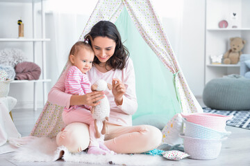 Happy woman and her little daughter playing at home © Pixel-Shot