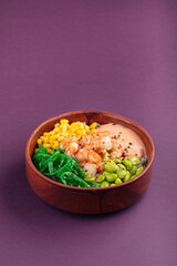 Hawaiian shrimp poke bowl with vegetables on purple background