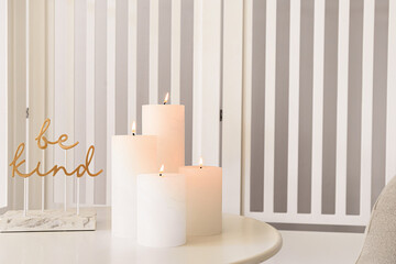 Burning candles on table in room