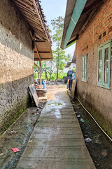 View of alley in a village in Asia rural area with unfinished house and dirty pavement.
