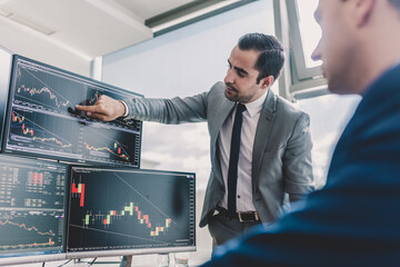 Stock brokers looking at computer screens, trading online.