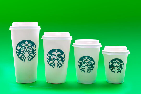Calgary, Alberta, Canada. May 19, 2021. Starbucks coffee cups of different sizes on a green background.