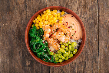 Hawaiian tuna poke bowl with vegetables on wooden background