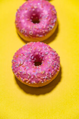 Fototapeta na wymiar pink donuts on yellow background 