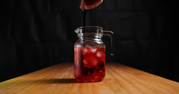 jug of red drink stirred with a straw