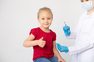 Woman doctor with a syringe and child showing thumb up.