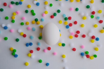 white egg and small yellow, red, green balls