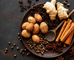 Gingerbread spices on slate - star anise, cinnamon, cloves, nutmeg, ginger, cardamom, black pepper