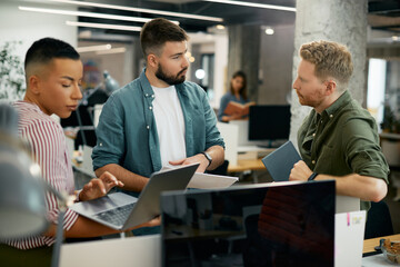 Young freelancer talking to coworkers during business meeting in the office.