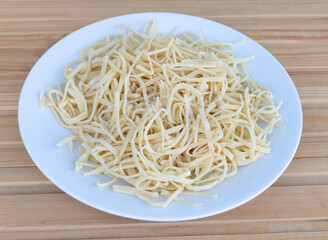 Fresh homemade pasta in a plate - wooden background. Recipe concept