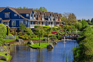 Fototapeta na wymiar Residential district with village of townhouses in a picturesque location near a pond with a fountain in the city of Richmond