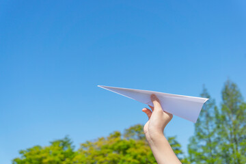A hand of the child who flies a paper airplane.  紙飛行機を飛ばす子供の手