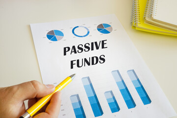 Business concept meaning PASSIVE FUNDS with sign on the printout with diagrams and tables.