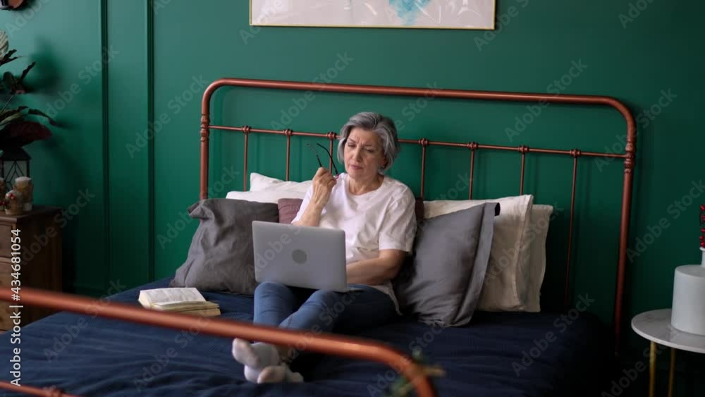 Poster aged female copywriter creating text publication during weekend remote working in home bedroom using