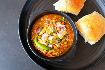 Spicy Misal Pav or usal Pav is a traditional snack or Chaat food from Maharashtra, India. Served with chopped onion, lemon wedges and farsan. Selective focus with copy space - obrazy, fototapety, plakaty